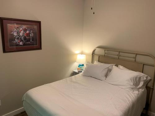 a bedroom with a white bed with a lamp on it at Villas at Gingershack Farms in Ellijay