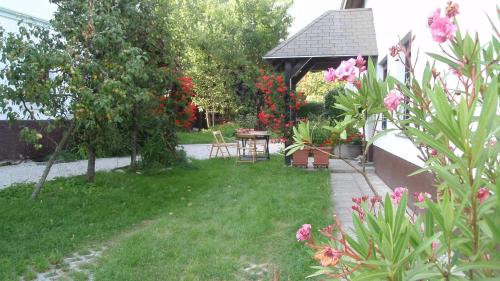 a garden with a gazebo with a table and flowers at Apartments Gregorc in Bled