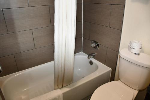 a bathroom with a toilet and a tub and a shower at Stillwater Inn & Suites in Stillwater