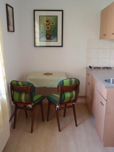 a small kitchen with a table and two chairs at Apartments Gregorc in Bled