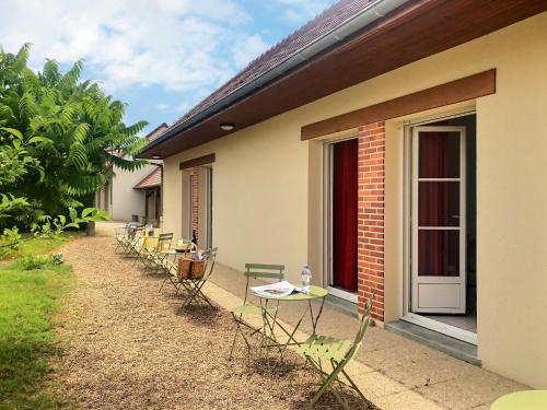 a row of chairs and tables next to a building at Logis Hôtel du Château in Tour-en-Sologne