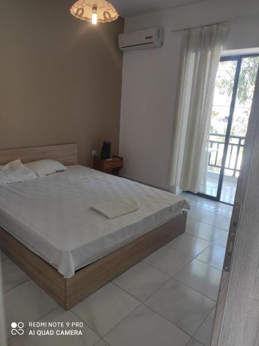a bedroom with a bed and a large window at Iris in Pefkohori