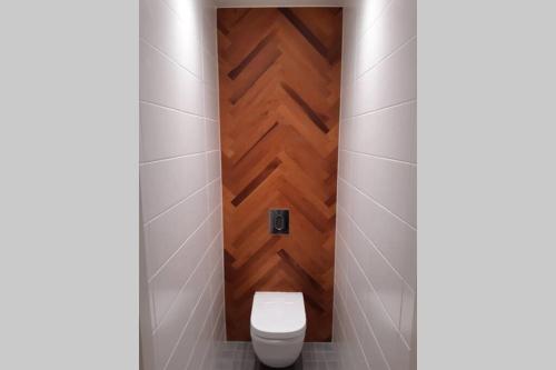 a bathroom with a toilet and a wooden door at Supeluse 6/2 külaliskorter in Pärnu