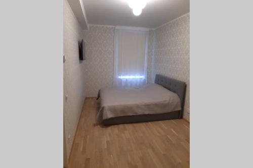 1 dormitorio pequeño con 1 cama y suelo de madera en Supeluse 6/2 külaliskorter en Pärnu
