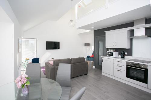 a kitchen and a living room with a glass table at 107 Eglinton Street in Portrush