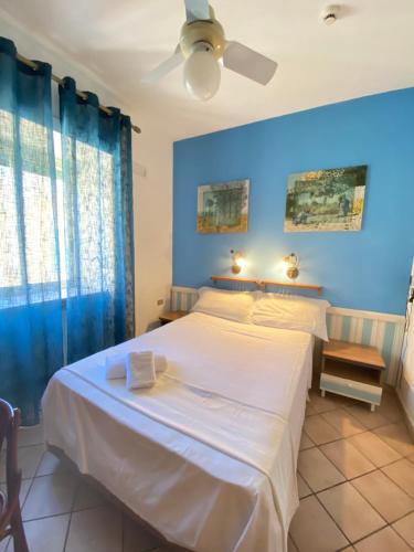 a bedroom with a large white bed with blue walls at Hotel Europeo Napoli in Naples