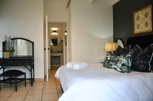 a bedroom with a white bed and a piano at Palm Cove - 10 Thira, Santorini, best view over Thompsons Beach in Ballito