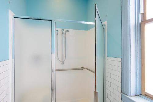 a shower with a glass door in a bathroom at Hostel Fish in Denver