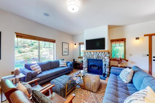 a living room with blue couches and a fireplace at Creekside Retreat in Rockaway Beach