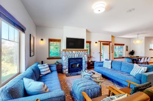 a living room with blue couches and a fireplace at Creekside Retreat in Rockaway Beach