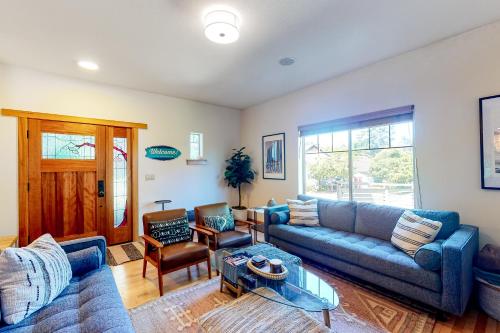 a living room with a blue couch and a table at Creekside Retreat in Rockaway Beach