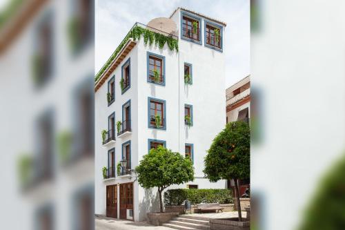 a white building with a tree in front of it at Sueño de Elvira in Granada