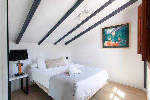 a bedroom with a white bed with a teddy bear on it at Sueño de Elvira in Granada