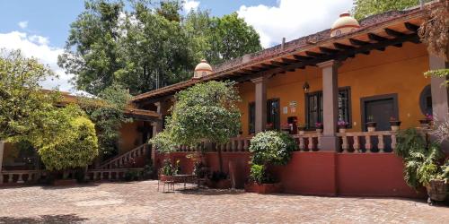 an old house with a courtyard and trees at Hotel Sautto in San Miguel de Allende