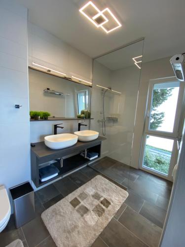 a bathroom with two sinks and a large mirror at VILLA OD MOORE STARIGRAD in Starigrad-Paklenica