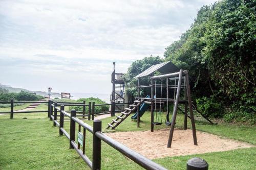 a playground with a slide in a park at Palm Cove - 10 Thira, Santorini, best view over Thompsons Beach in Ballito