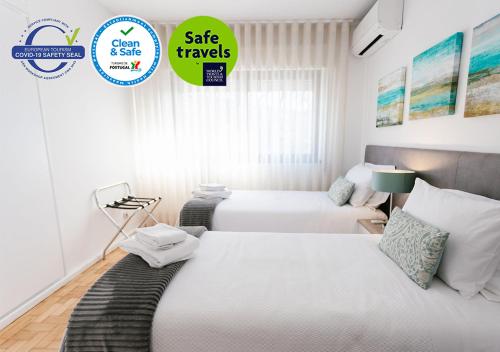 a bedroom with two beds and a sign that says sale travels at Mumadona Apartment in Guimarães