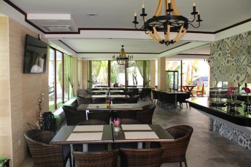 a restaurant with tables and chairs and a chandelier at Sun Village Aparthotel in Herceg-Novi