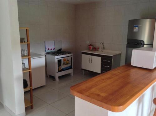 a small kitchen with a refrigerator and a stove at Barbosa acomodações. Lencois-BA in Lençóis