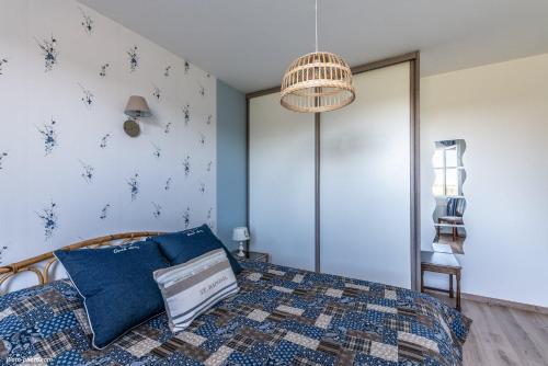 a bedroom with a bed with a blue quilt at Chambre d'hôtes de la Fontagrille in Épineuil-le-Fleuriel