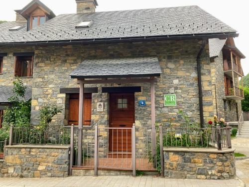 a stone house with a gate in front of it at Casa Campolé in San Juan de Plan