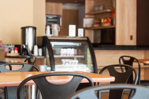 a restaurant with tables and chairs and a counter at Ibeurohotel Guadalajara Expo in Guadalajara
