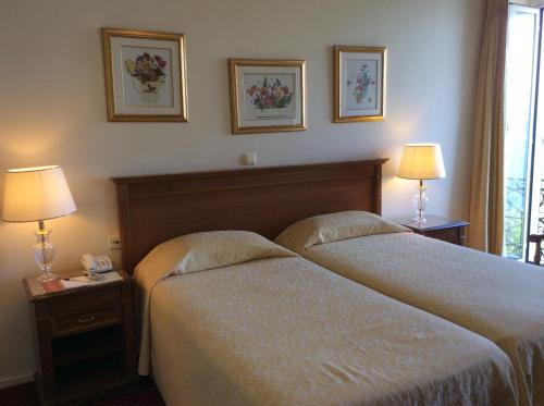 a hotel room with two beds and two lamps at Cavalieri Hotel in Corfu Town