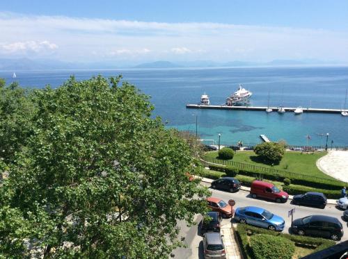 a parking lot with a cruise ship in the water at Cavalieri Hotel in Corfu Town