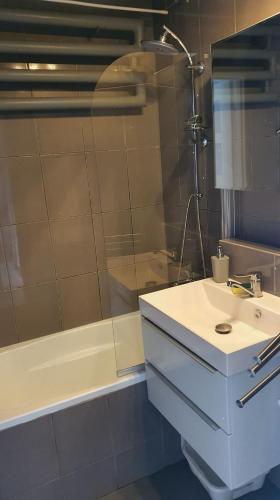 a bathroom with a sink and a shower at Apartament New Jork in Olsztyn