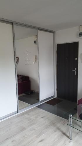 an empty room with glass doors and a couch at Apartament New Jork in Olsztyn