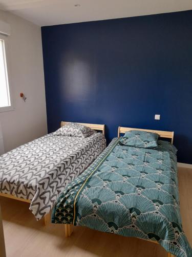 Duas camas sentadas uma ao lado da outra num quarto em Maison petit ion jean mi et flo em Vendays-Montalivet