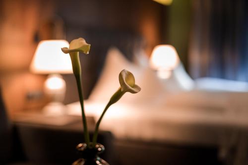 a vase with a white flower in a room at Boutique Hotel Mandarfnerhof in Sankt Leonhard im Pitztal