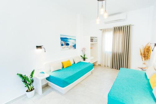 a living room with white walls and a blue couch at Floresita apartment in Fira