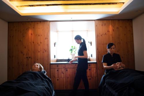 two women standing in a room with two beds at Åkerblads Hotell Gästgiveri Spa in Tällberg