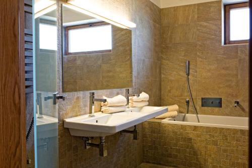 a bathroom with a sink and a mirror and a tub at Vinařský Penzion in Strachotice