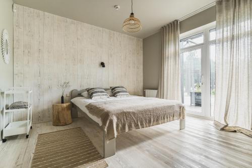 a bedroom with a bed and a large window at Guest House Garoza with Self Check-in in Tūja