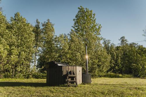 a wooden out house in a field with trees at Guest House Garoza with Self Check-in in Tūja
