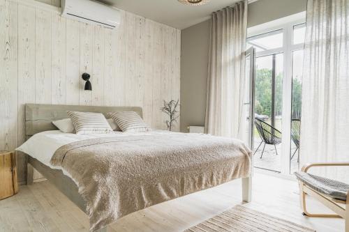 a bedroom with a bed and a large window at Guest House Garoza with Self Check-in in Tūja