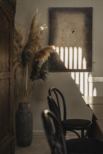 a vase with a table and a chair in a room at Guest House Garoza with Self Check-in in Tūja
