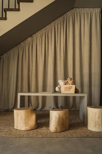 a table and two stools in front of a curtain at Guest House Garoza with Self Check-in in Tūja