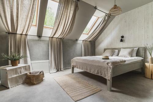 1 dormitorio con 1 cama en una habitación con ventanas en Guest House Garoza, en Tuja
