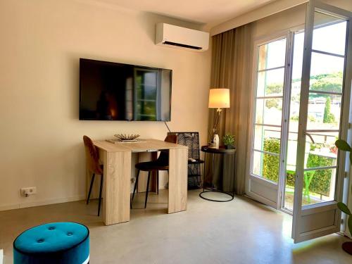 ein Wohnzimmer mit einem Tisch und einem großen Fenster in der Unterkunft St Tropez T2 central in Saint-Tropez