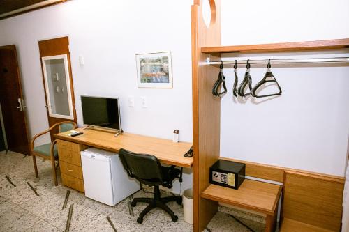 an office with a desk with a computer and a chair at Fênix Hotel Varginha in Varginha