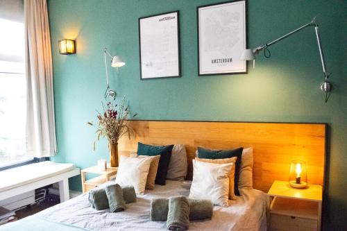 PERFECT B&B MIDDLE OF AMSTERDAM في أمستردام: غرفة نوم مع سرير مع اللوح الأمامي الخشبي