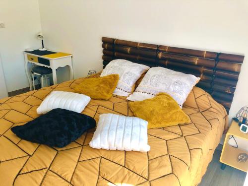 una cama con almohadas blancas encima en La Croisée Chambre d hôte avec sanitaires partagés, en Guéreins
