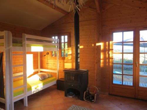 - une chambre avec un poêle à bois et des lits superposés dans l'établissement Gîte de l'Oursonnière, à Saint-Laurent-dʼOingt