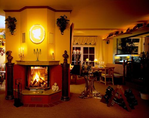 a living room with a fireplace in front of it at Gasthaus Stobbermühle in Buckow