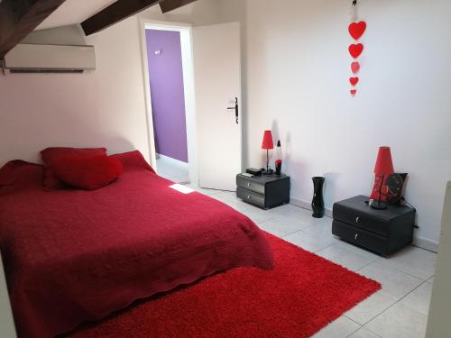 - une chambre avec un lit rouge et un tapis rouge dans l'établissement Appartement meublé à Villeneuve les maguelone, à Villeneuve-lès-Maguelone