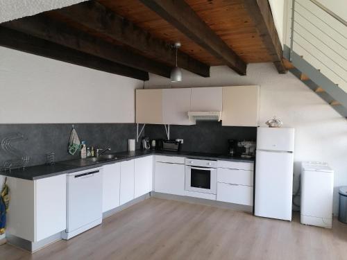 une cuisine avec des appareils blancs et un parquet dans l'établissement Appartement meublé à Villeneuve les maguelone, à Villeneuve-lès-Maguelone