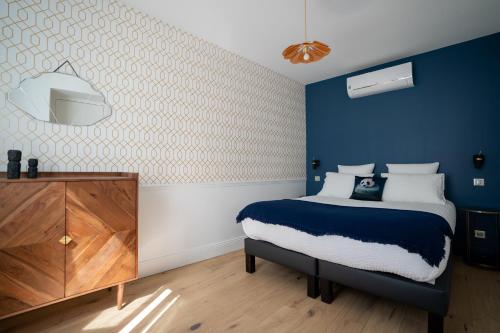 a blue and white bedroom with a bed and a dresser at KRAFFT, centre ville, climatisé, baignoire double - La Clé des Sacres in Reims